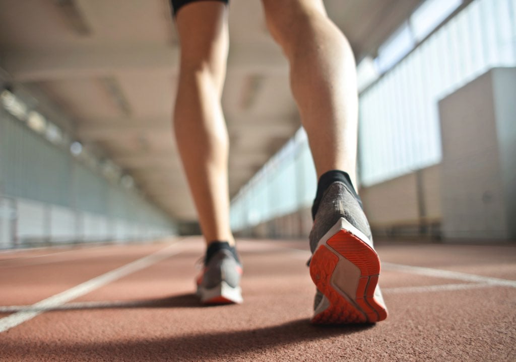 Feet and legs of an athlete on a running track 